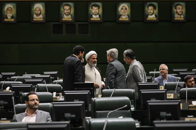 October 25, 2026, Tehran, Iran: A white-turbaned cleric talks with a group of men in the center of the chamber beneath a row of framed portraits at the Islamic Consultative Assembly in Tehran, Iran, on October 25, 2026. Speaker Mohammad Bagher Ghalibaf chaired the October 25 session, which combined physical attendance at the Islamic Consultative Assembly with participation by video link. Tehran Iran - ZUMAi98_ 20261025_zih_i98_054 Copyright: xIcanax