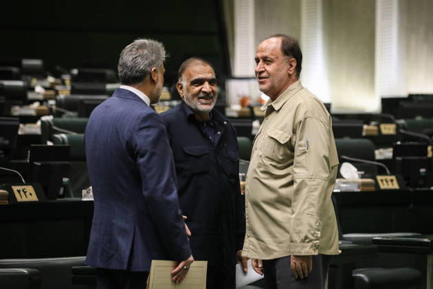 October 25, 2026, Tehran, Iran: Three suited lawmakers stand in conversation, including a man in a beige jacket, amid the green parliamentary seats at the Islamic Consultative Assembly in Tehran, Iran, on October 25, 2026. The Islamic Consultative Assembly resumed an open sitting in its Tehran chamber with a mix of in-person and remote participation, according to parliamentary reporting. Tehran Iran - ZUMAi98_ 20261025_zih_i98_072 Copyright: xIcanax