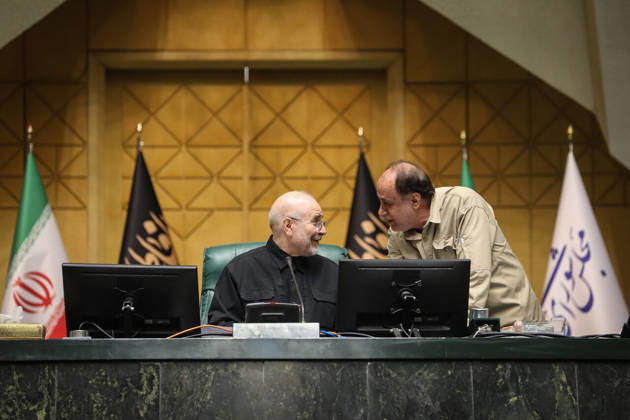 October 25, 2026, Tehran, Iran: Mohammad Bagher Ghalibaf turns toward a man in a beige shirt leaning over the presiding desk at the Islamic Consultative Assembly in Tehran, Iran, on October 25, 2026. The Iranian parliament held a hybrid open sitting, with some lawmakers attending in the Tehran chamber and others participating remotely, according to parliamentary reports. Tehran Iran - ZUMAi98_ 20261025_zih_i98_097 Copyright: xIcanax