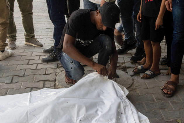 Gaza Israeli University Strike 2026 A Palestinian mourner crouches beside a white body bag while others stand nearby ahead of a funeral in Gaza City, Palestine, on October 25, 2026. According to information provided by local sources, three Islamic University guards, Ashraf Dahlan, Shadi Abu Ataya and Sami Baroud, were killed and others injured in an Israeli strike on the university campus in western Gaza City. Palestinian media reported that a second drone strike hit the campus after an earlier attack injured several people and prompted the university to suspend activities. Gaza Gaza Strip Palestinian Territories Copyright: xHassanxSalemx