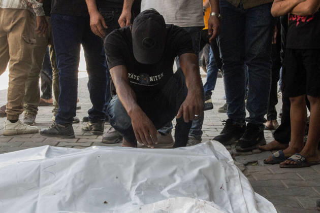 Gaza Israeli University Strike 2026 A Palestinian mourner crouches beside a white body bag while others stand nearby ahead of a funeral in Gaza City, Palestine, on October 25, 2026. According to information provided by local sources, three Islamic University guards, Ashraf Dahlan, Shadi Abu Ataya and Sami Baroud, were killed and others injured in an Israeli strike on the university campus in western Gaza City. Palestinian media reported that a second drone strike hit the campus after an earlier attack injured several people and prompted the university to suspend activities. Gaza Gaza Strip Palestinian Territories Copyright: xHassanxSalemx