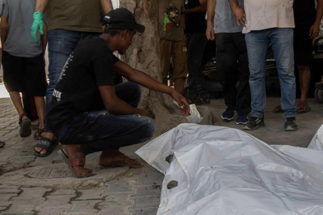 Gaza Israeli University Strike 2026 A Palestinian mourner crouches beside a white body bag while others stand nearby ahead of a funeral in Gaza City, Palestine, on October 25, 2026. According to information provided by local sources, three Islamic University guards, Ashraf Dahlan, Shadi Abu Ataya and Sami Baroud, were killed and others injured in an Israeli strike on the university campus in western Gaza City. Palestinian media reported that a second drone strike hit the campus after an earlier attack injured several people and prompted the university to suspend activities. Gaza Gaza Strip Palestinian Territories Copyright: xHassanxSalemx