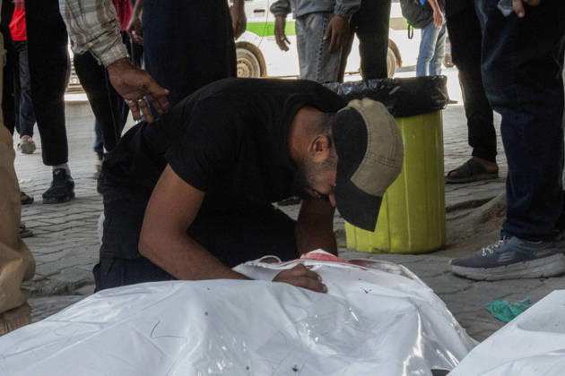 Gaza Israeli University Strike 2026 A Palestinian mourner bends over a white body bag in Gaza City, Palestine, on October 25, 2026. According to information provided by local sources, three Islamic University guards, Ashraf Dahlan, Shadi Abu Ataya and Sami Baroud, were killed and others injured in an Israeli strike on the university campus in western Gaza City. Palestinian media reported that a second drone strike hit the campus after an earlier attack injured several people and prompted the university to suspend activities. Gaza Gaza Strip Palestinian Territories Copyright: xHassanxSalemx