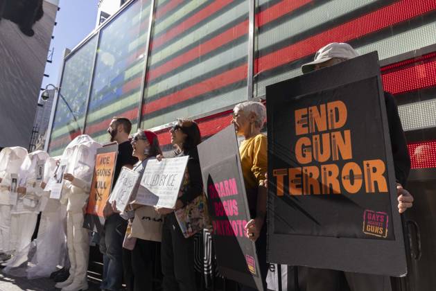 October 25, 2026, New York, New York, USA: Demonstrators with the anti-gun violence organization Gays Against Guns protest under the Times Square US Army Recruiting Station LED American flag to denounce U.S. Immigration and Customs Enforcement (ICE) and President Trump s immigrant detention and mass deportation policies. People dressed in white shrouds are Human Beings, memorializing people killed by gun violence from Federal immigration agents by holding signs with their images and names. Protesters chant holding signs that read ICE GUNS KILL US DISARM BOGUS PATRIOTS END GUN TERROR. New York USA  - ZUMAr174 20261025_znp_r174_002 Copyright: xGinaxMxRandazzox
