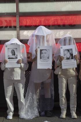 October 25, 2026, New York, New York, USA: People dressed in white shrouds are Human Beings, memorializing people killed by gun violence from Federal immigration agents by holding signs with the images and names of Renee Nicole Good Silverio Villegas Gonzalez Jonah Neal. Demonstrators with the anti-gun violence organization Gays Against Guns protest under the Times Square US Army Recruiting Station LED American flag to denounce U.S. Immigration and Customs Enforcement (ICE,) President Trump s immigrant detention and mass deportation policies. New York USA  - ZUMAr174 20261025_znp_r174_018 Copyright: xGinaxMxRandazzox
