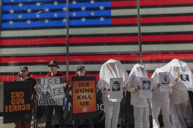 October 25, 2026, New York, New York, USA: Demonstrators with the anti-gun violence organization Gays Against Guns protest under the Times Square US Army Recruiting Station LED American flag to denounce U.S. Immigration and Customs Enforcement (ICE) and President Trump s immigrant detention and mass deportation policies. Protesters hold signs that read END GUN TERROR ICE IS A HATE CRIME ICE GUNS KILL US. People dressed in white shrouds are Human Beings, memorializing people killed by gun violence from Federal immigration agents by holding signs with their images and names. New York USA - ZUMAr174 20261025_znp_r174_005 Copyright: xGinaxMxRandazzox