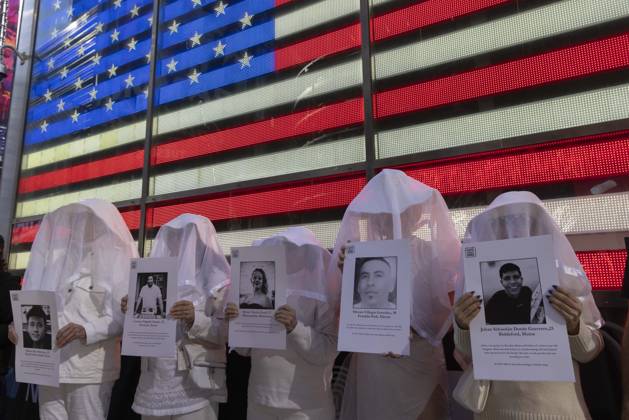 October 25, 2026, New York, New York, USA: People dressed in white shrouds are Human Beings, memorializing people killed by gun violence from Federal immigration agents by holding signs with the images and names of Ruben Ray Martinez Lorenzo Salgado Araujo Renee Nicole Good Silverio Villegas Gonzalez Johan Sebastian Duran Guerrero. Demonstrators with the anti-gun violence organization Gays Against Guns protest under the Times Square US Army Recruiting Station LED American flag to denounce U.S. Immigration and Customs Enforcement (ICE,) President Trump s immigrant detention and mass deportation policies. New York USA - ZUMAr174 20261025_znp_r174_008 Copyright: xGinaxMxRandazzox