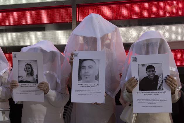 October 25, 2026, New York, New York, USA: People dressed in white shrouds are Human Beings, memorializing people killed by gun violence from Federal immigration agents by holding signs with the images and names of Renee Nicole Good Silverio Villegas Gonzalez Johan Sebastian Duran Guerrero. Demonstrators with the anti-gun violence organization Gays Against Guns protest under the Times Square US Army Recruiting Station LED American flag to denounce U.S. Immigration and Customs Enforcement (ICE,) President Trump s immigrant detention and mass deportation policies. New York USA - ZUMAr174 20261025_znp_r174_009 Copyright: xGinaxMxRandazzox