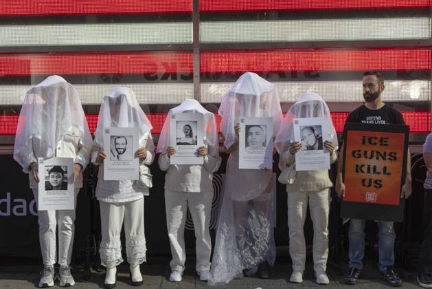 October 25, 2026, New York, New York, USA: People dressed in white shrouds are Human Beings, memorializing people killed by gun violence from Federal immigration agents by holding signs with the images and names of Ruben Ray Martinez Alex Jeffrey Pretti Renee Nicole Good Silverio Villegas Gonzalez Jonah Neal. Demonstrators with the anti-gun violence organization Gays Against Guns protest under the Times Square US Army Recruiting Station LED American flag to denounce U.S. Immigration and Customs Enforcement (ICE,) President Trump s immigrant detention and mass deportation policies. Protesters hold signs that read ICE GUNS KILL US. New York USA - ZUMAr174 20261025_znp_r174_017 Copyright: xGinaxMxRandazzox