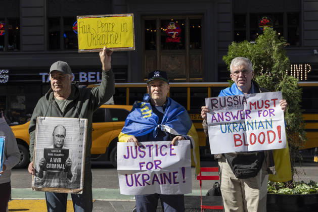 October 25, 2026, New York, New York, USA: Demonstrators in Times Square wear Ukrainian flags and hold signs that read Fair Peace in Ukraine! a sign with an image of President of Russia V. Putin in a mugshot that reads A WAR CRIMINAL. JUSTICE FOR UKRAINE! RUSSIA MUST ANSWER FOR UKRAINIAN BLOOD! New York USA - ZUMAr174 20261025_znp_r174_022 Copyright: xGinaxMxRandazzox