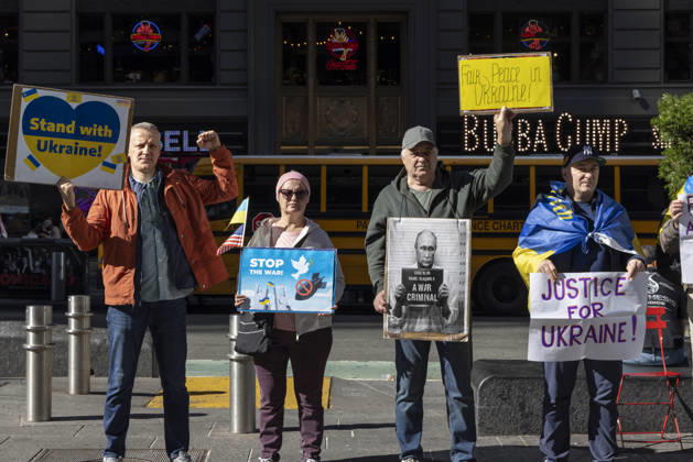 October 25, 2026, New York, New York, USA: Demonstrators in Times Square wear Ukrainian flags and hold signs that read Stand with Ukraine! STOP THE WAR! Fair Peace in Ukraine! a sign with an image of President of Russia V. Putin in a mugshot that reads A WAR CRIMINAL. JUSTICE FOR UKRAINE! New York USA - ZUMAr174 20261025_znp_r174_023 Copyright: xGinaxMxRandazzox
