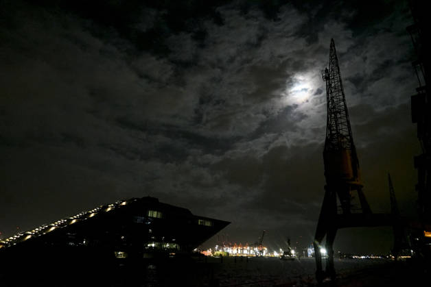 CNTV FLOODING: A hazy full moon in the sky; fall flooding in the Port of Hamburg, the Hamburg Fish Market and the Oevelgoenne parking lot were flooded by the Elbe; in the fish auction hall, the water was about 50 cm deep. Hamburg, October 26, 2026. The combination of the full moon and the storm surge caused the Elbe flooding in Hamburg, Germany.