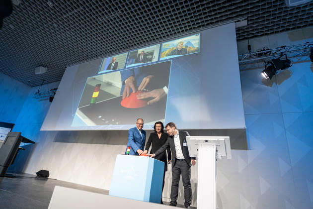 Dorothee Bär, Federal Minister of Research; Andreas Tünnermann, Fraunhofer IOF, spokesperson for the QuNET Initiative (on the left in the photo); and Christoph Marquardt, FAU MPL, Scientific Director of the key experiment and the live demonstration, press the red button buzz