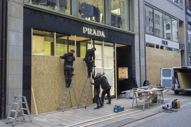 CNTV STORE PROTECTION: Storefronts and windows are boarded up with large wooden panels to protect them from looting. Workers are installing large wooden panels, particleboard, and barricades in front of stores. There is great fear of vandalism by demonstrators. October 31, 2026 Downtown Hamburg, Hamburg, Germany