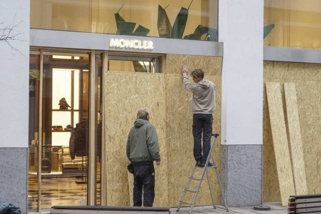 CNTV STORE PROTECTION: Storefronts and windows are boarded up with large wooden panels to protect them from looting. Workers are installing large wooden panels, particleboard, and barricades in front of stores. There is great fear of vandalism by demonstrators. October 31, 2026 Downtown Hamburg, Hamburg, Germany
