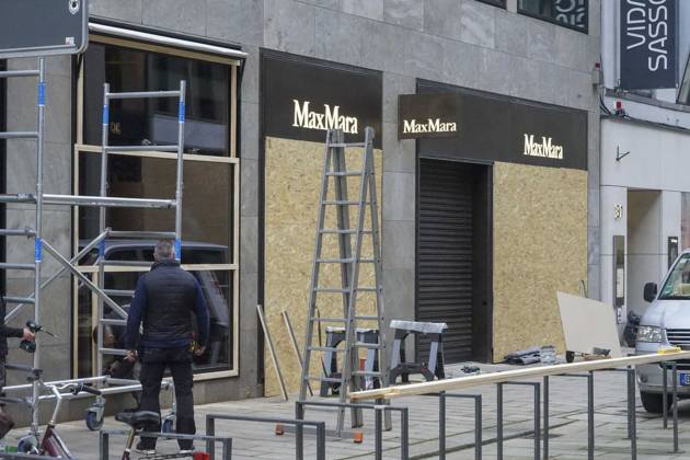 CNTV STORE PROTECTION: Storefronts and windows are boarded up with large wooden panels to protect them from looting. Workers are installing large wooden panels, particleboard, and barricades in front of stores. There is great fear of vandalism by demonstrators. October 31, 2026 Downtown Hamburg, Hamburg, Germany