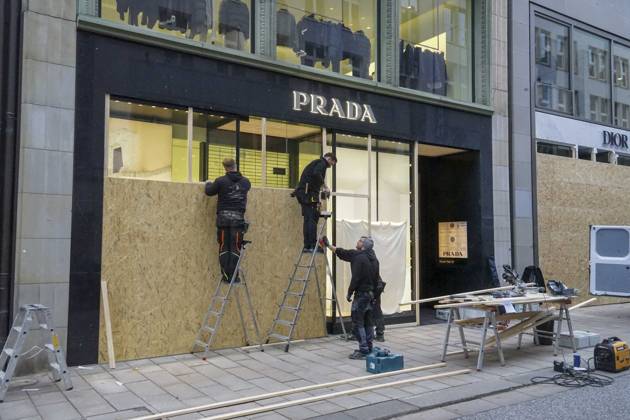 CNTV STORE PROTECTION: Storefronts and windows are boarded up with large wooden panels to protect them from looting. Workers are installing large wooden panels, particleboard, and barricades in front of stores. There is great fear of vandalism by demonstrators. October 31, 2026 Downtown Hamburg, Hamburg, Germany