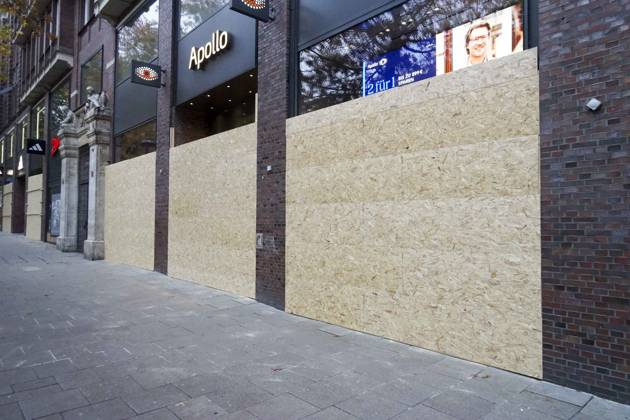 CNTV STORE PROTECTION: Storefronts and windows are boarded up with large wooden panels to protect them from looting. Workers are installing large wooden panels, particleboard, and barricades in front of stores. There is great fear of vandalism by demonstrators. October 31, 2026 Downtown Hamburg, Hamburg, Germany