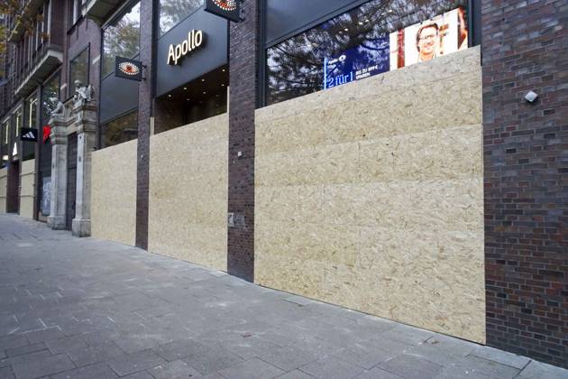 CNTV STORE PROTECTION: Storefronts and windows are boarded up with large wooden panels to protect them from looting. Workers are installing large wooden panels, particleboard, and barricades in front of stores. There is great fear of vandalism by demonstrators. October 31, 2026 Downtown Hamburg, Hamburg, Germany