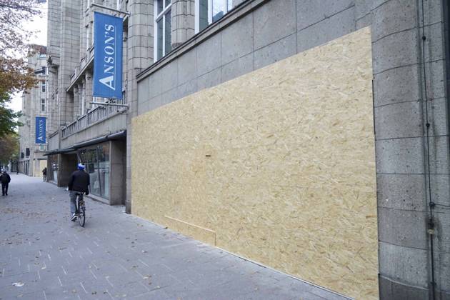 CNTV STORE PROTECTION: Storefronts and windows are boarded up with large wooden panels to protect them from looting. Workers are installing large wooden panels, particleboard, and barricades in front of stores. There is great fear of vandalism by demonstrators. October 31, 2026 Downtown Hamburg, Hamburg, Germany