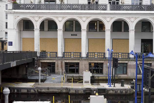CNTV STORE PROTECTION: Storefronts and windows are boarded up with large wooden panels to protect them from looting. Workers are installing large wooden panels, particleboard, and barricades in front of stores. There is great fear of vandalism by demonstrators. October 31, 2026 Downtown Hamburg, Hamburg, Germany
