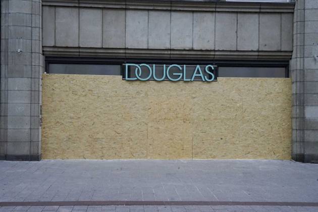 CNTV STORE PROTECTION: Storefronts and windows are boarded up with large wooden panels to protect them from looting. Workers are installing large wooden panels, particleboard, and barricades in front of stores. There is great fear of vandalism by demonstrators. October 31, 2026 Downtown Hamburg, Hamburg, Germany