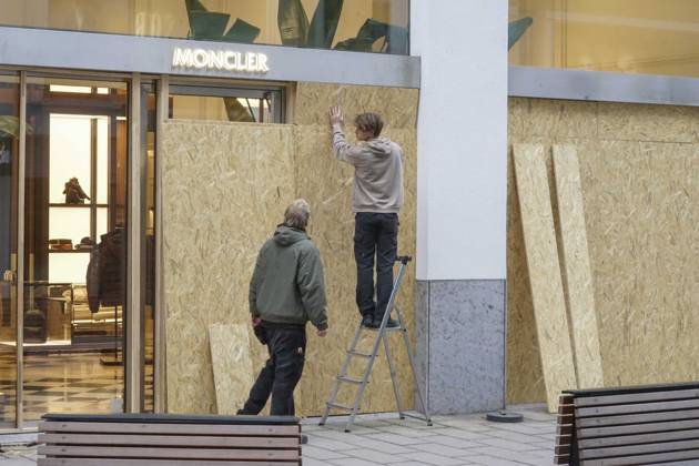 CNTV STORE PROTECTION: Storefronts and windows are boarded up with large wooden panels to protect them from looting. Workers are installing large wooden panels, particleboard, and barricades in front of stores. There is great fear of vandalism by demonstrators. October 31, 2026 Downtown Hamburg, Hamburg, Germany